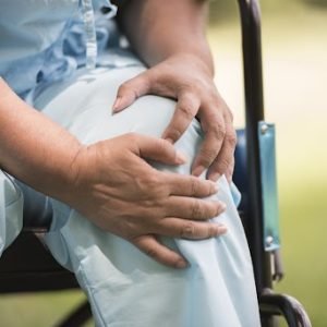 Elderly woman sitting on wheelchairs with knee pain